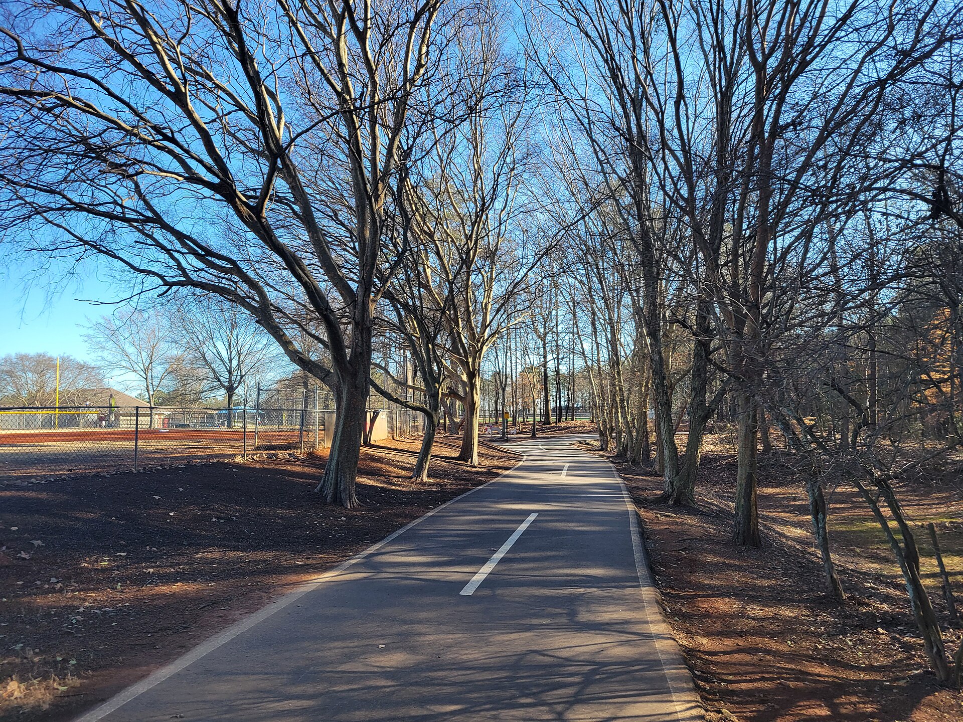 A tree-lined walking path in Johns Creek’s Newtown Park